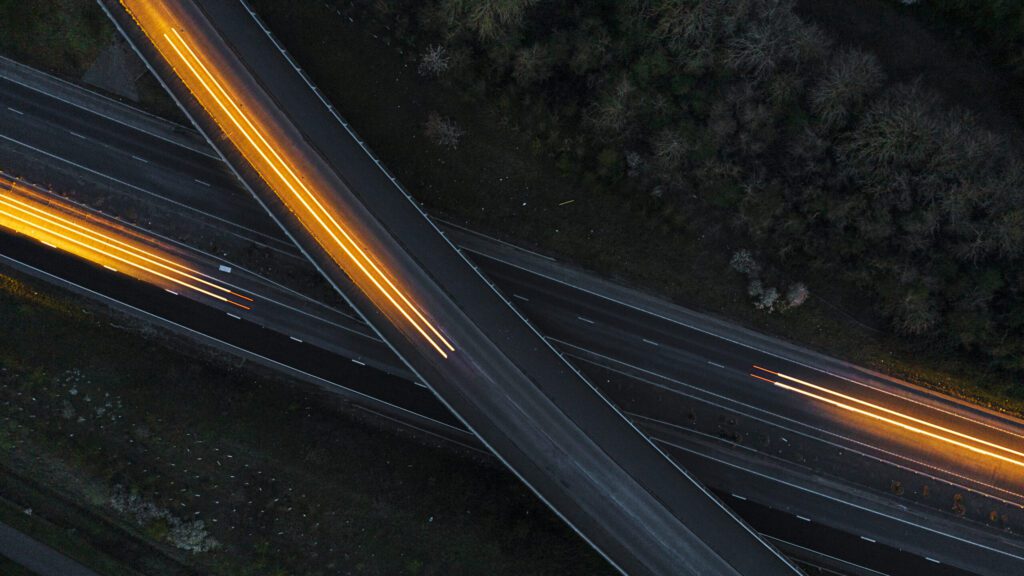 在夜间朝着不同方向移动的汽车的无人机视图